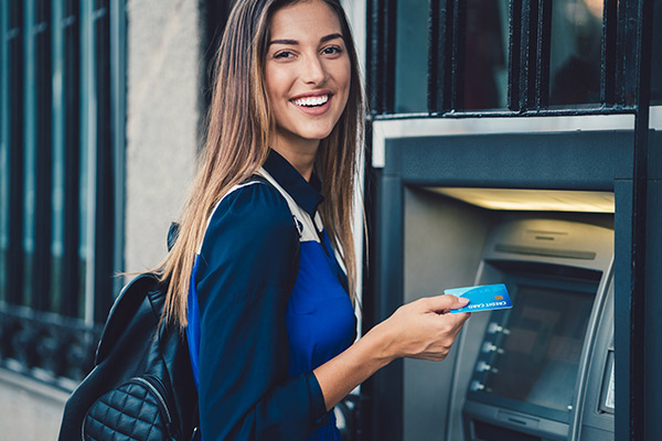 Person using their card at an atm to get cash.