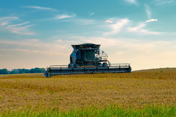 Large farming equipment out in the field working.