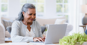 mature woman typing on her laptop computer