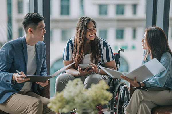 Bankers meeting with a person in a wheelchair.