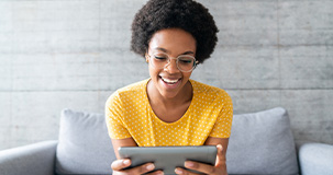 a woman wearing glasses viewing her tablet