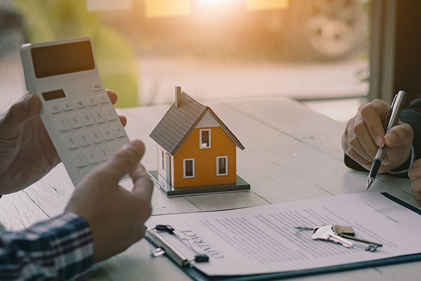 Person holding a calculator getting ready to sign a mortgage contract.