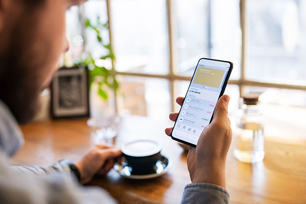 Person having coffee using their phone to bank.