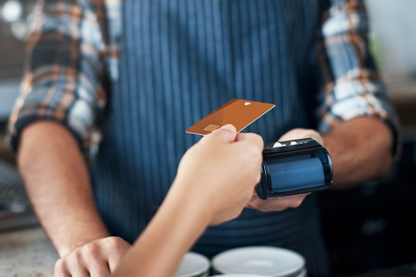 Person paying for their purchase with a debit card.