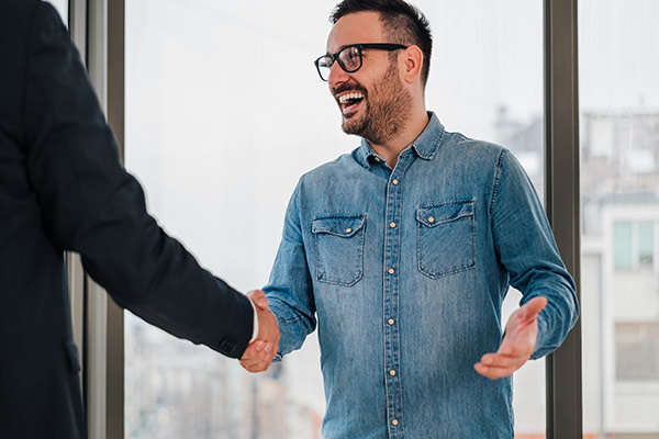 Person shaking hands with a business professional.