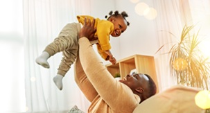 Dad holding baby in air image