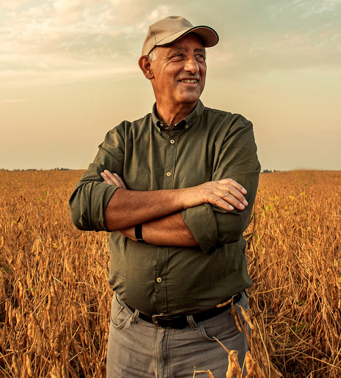 Farmer standing in a field of crops thinking about a business loan.